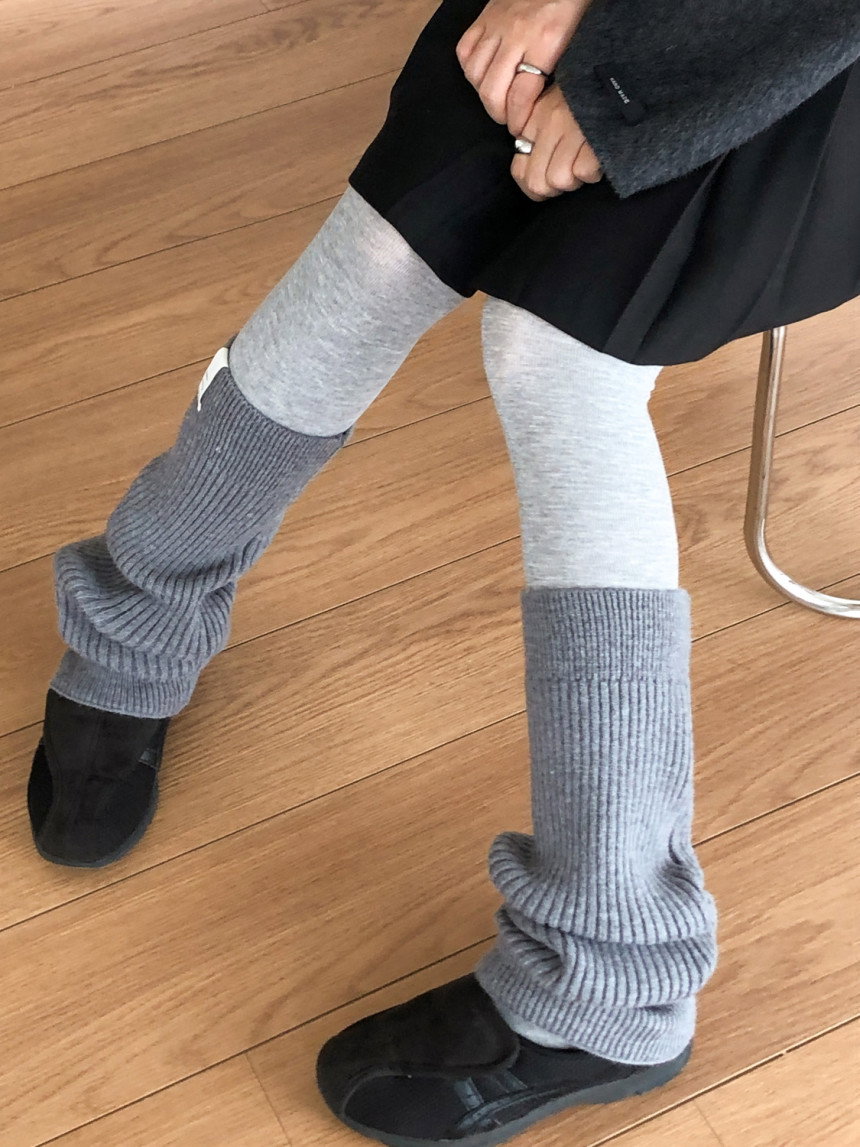 Grey ribbed leg warmers layered over light grey tights with a dark grey sweater and black mini skirt
