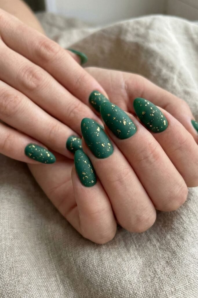 Deep emerald green nails with gold foil accents