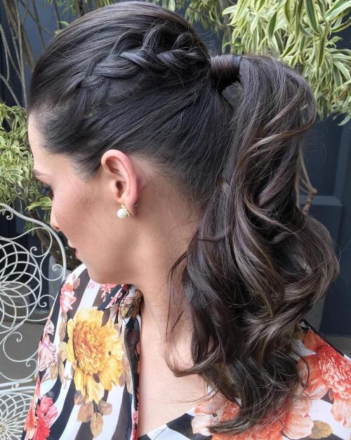 Ponytail with a French braid along one side and soft waves