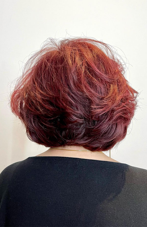 Short coppery mahogany bob on a mature woman, back view