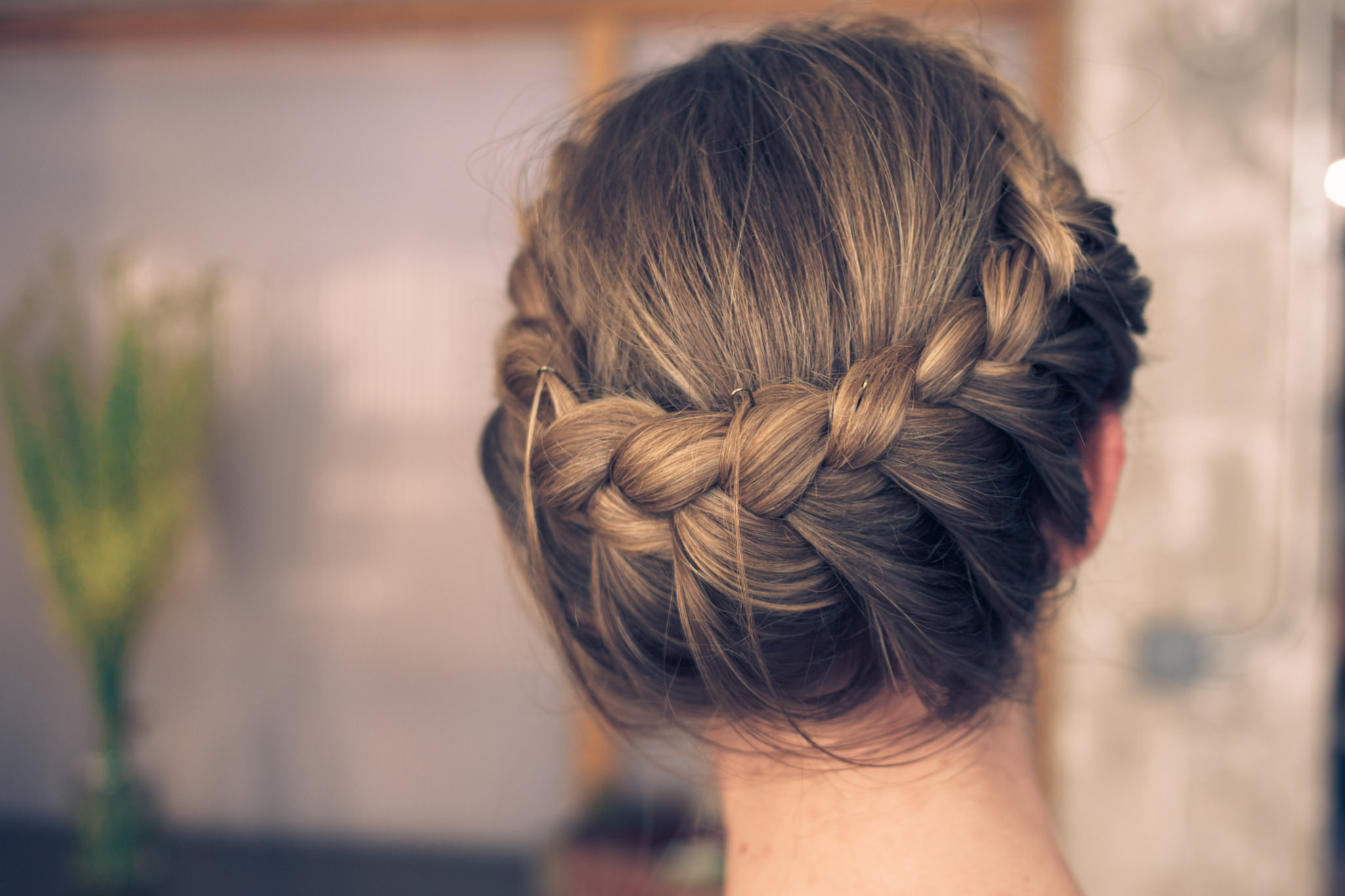 Back view of a milkmaid braid crown wrapped around the head in brown hair