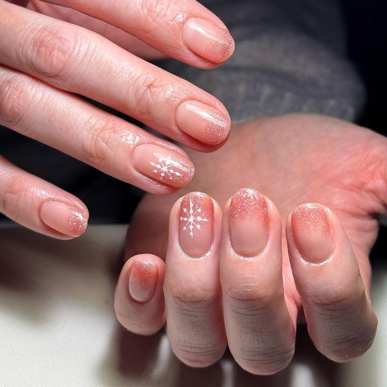 Short sheer nude Christmas nails with red glitter fade at the tips and a white snowflake accent