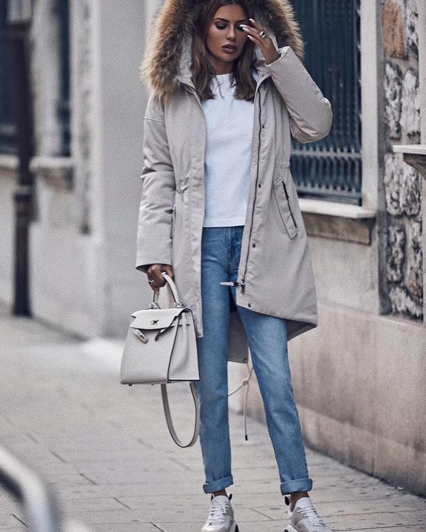 Woman wearing Ugg Tasman slippers with a hooded parka and jeans