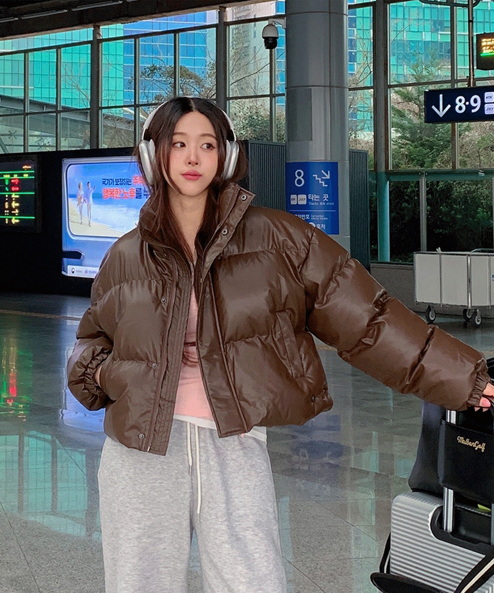Woman wearing a puffer jacket with leggings and sneakers, styled for airport travel