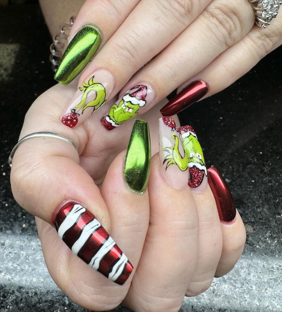 Coffin nails in grinch-green chrome with hand-painted Grinch face art, red glitter, and candy-stripe accents