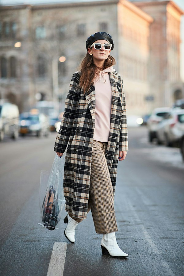 Street style photo of a woman wearing a beret with a check coat and plaid pants