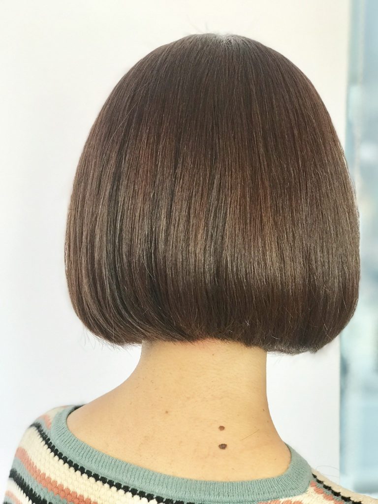 Back view of a smooth rounded dark-brown bob with tucked-under ends