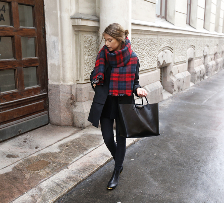 Woman wearing a tartan scarf with a winter coat