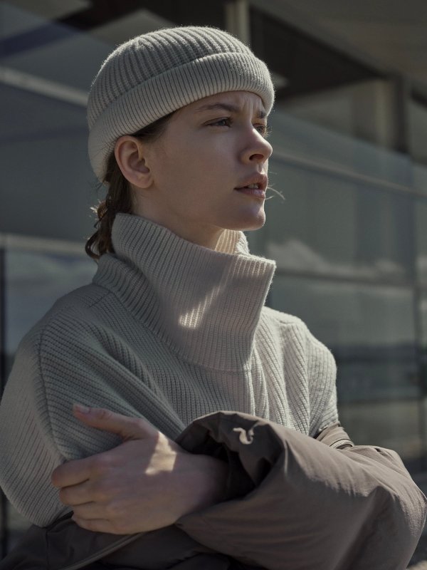 Woman in a cream beanie and cream ribbed turtleneck
