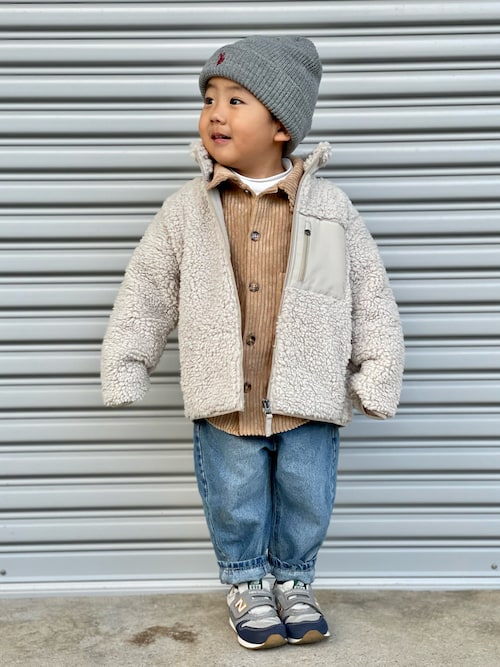 A kid wearing a sherpa-lined denim jacket with jeans in a street-style photo