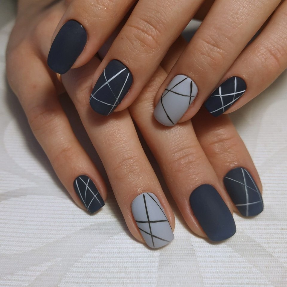 Squoval nails with matte navy and gray geometric line art