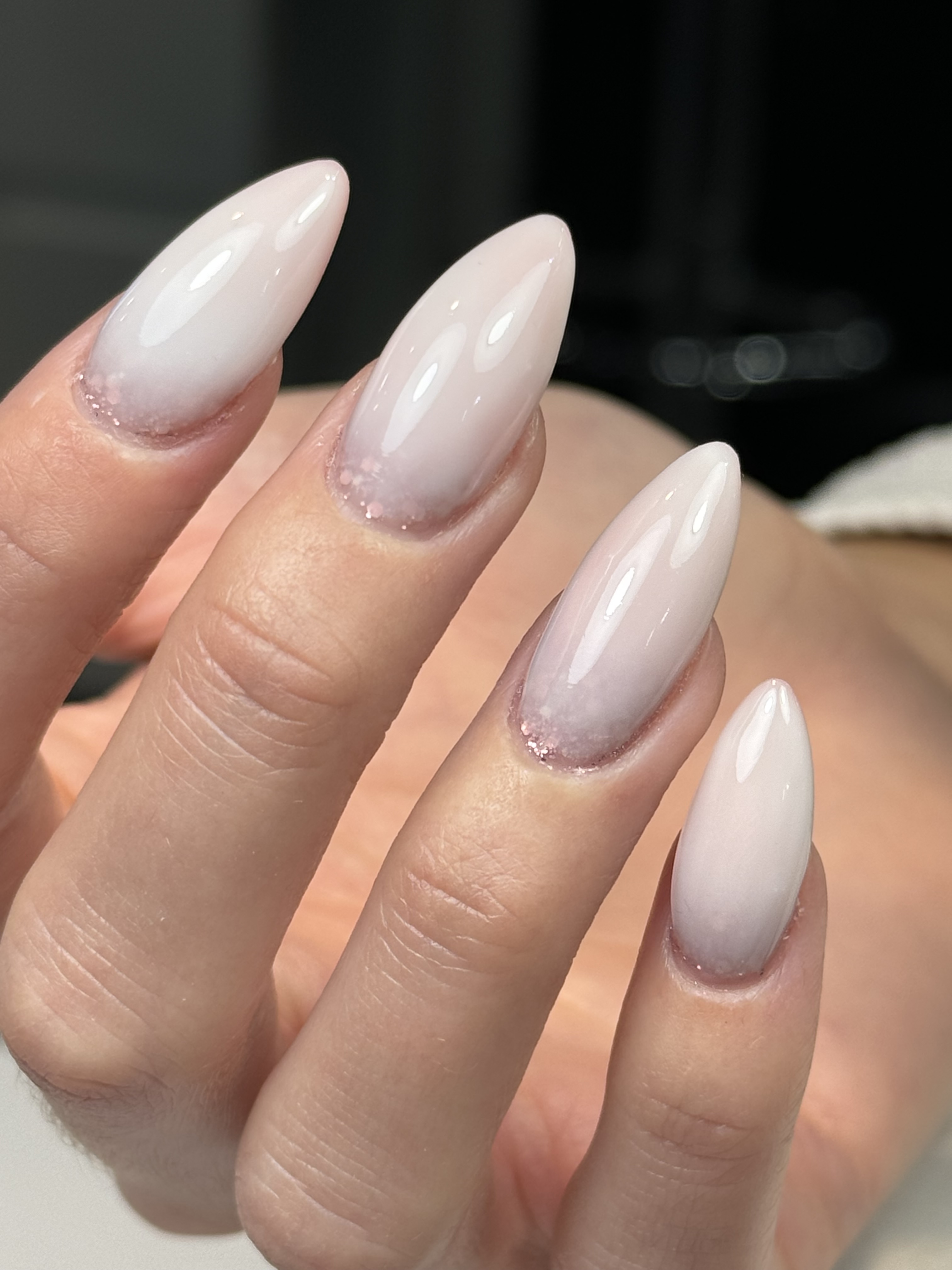 Almond nails with milky-white tips melting into a clear glass-like natural base
