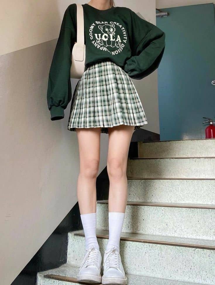 Green graphic sweatshirt with plaid pleated mini skirt, white socks and sneakers