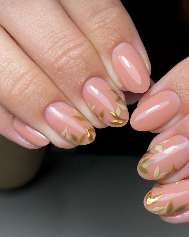 Sheer nude almond nails with delicate gold branch art