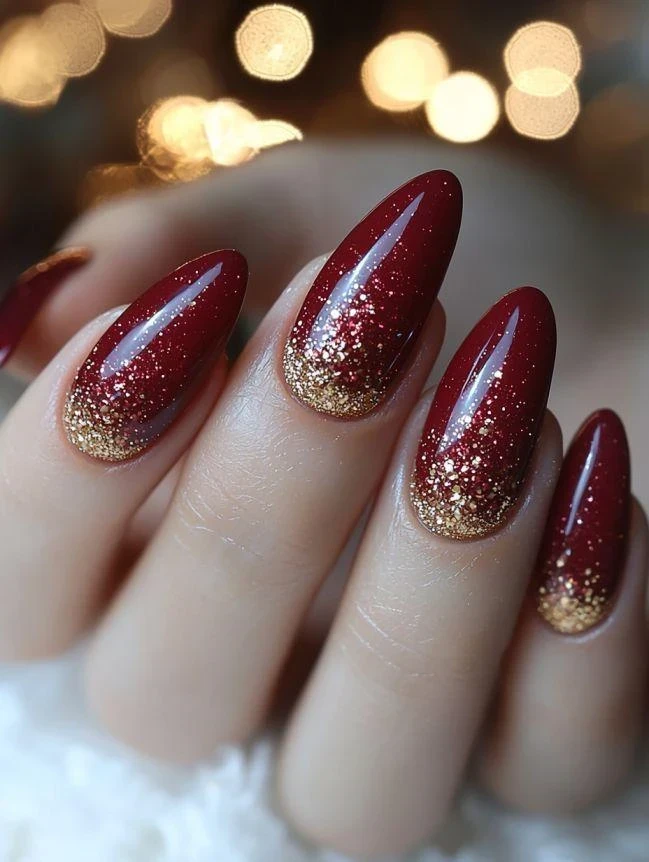 Deep red nails tipped with sparkling gold glitter