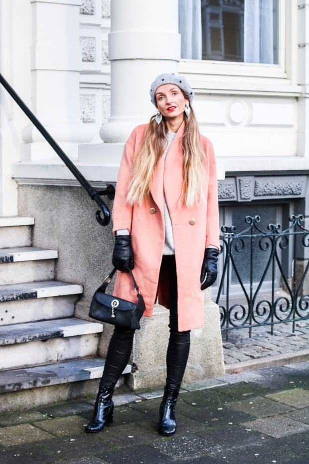 Woman in a pink coat with dark jeans in a winter outfit