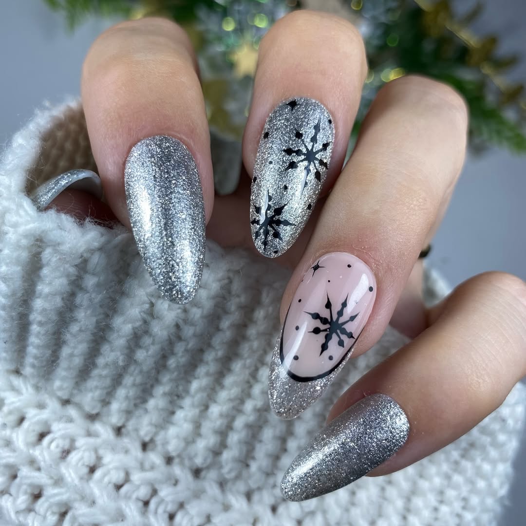 Silver glitter nails with black snowflake nail art accents