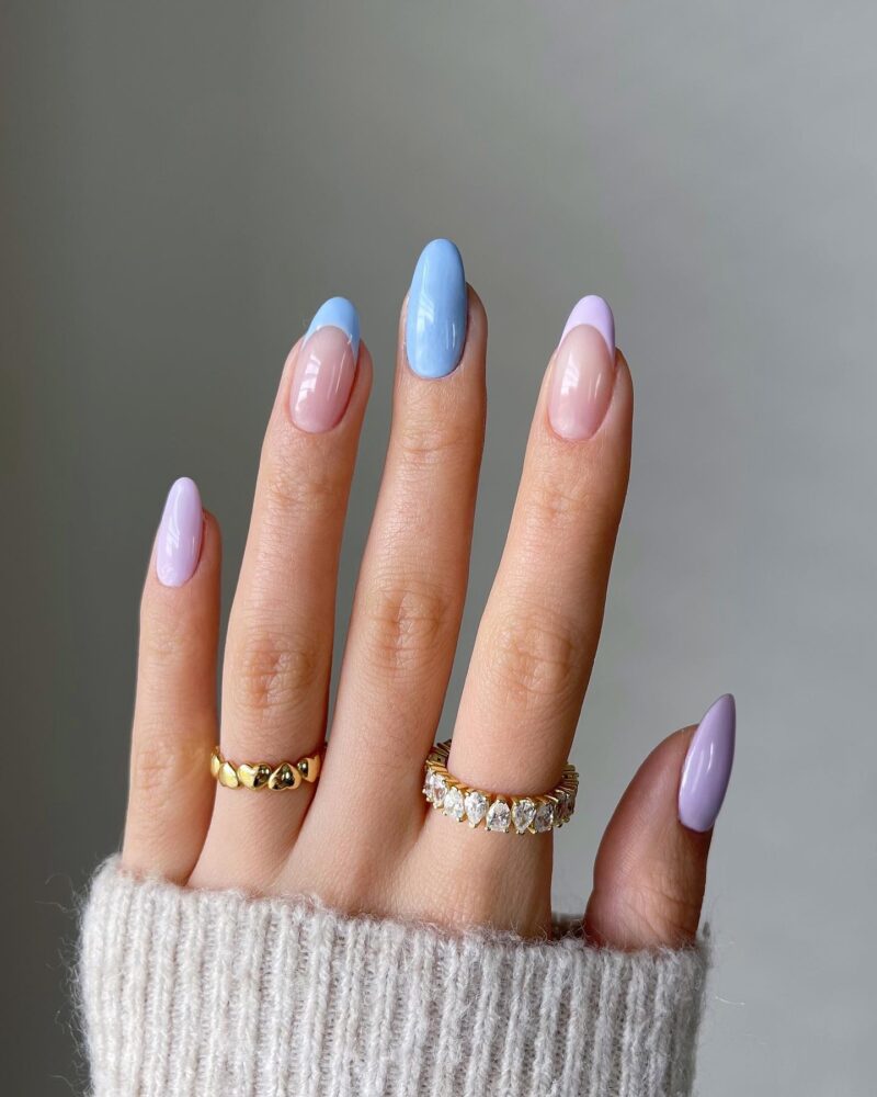 Almond nails with sheer nude base and pastel periwinkle blue and lavender french tips
