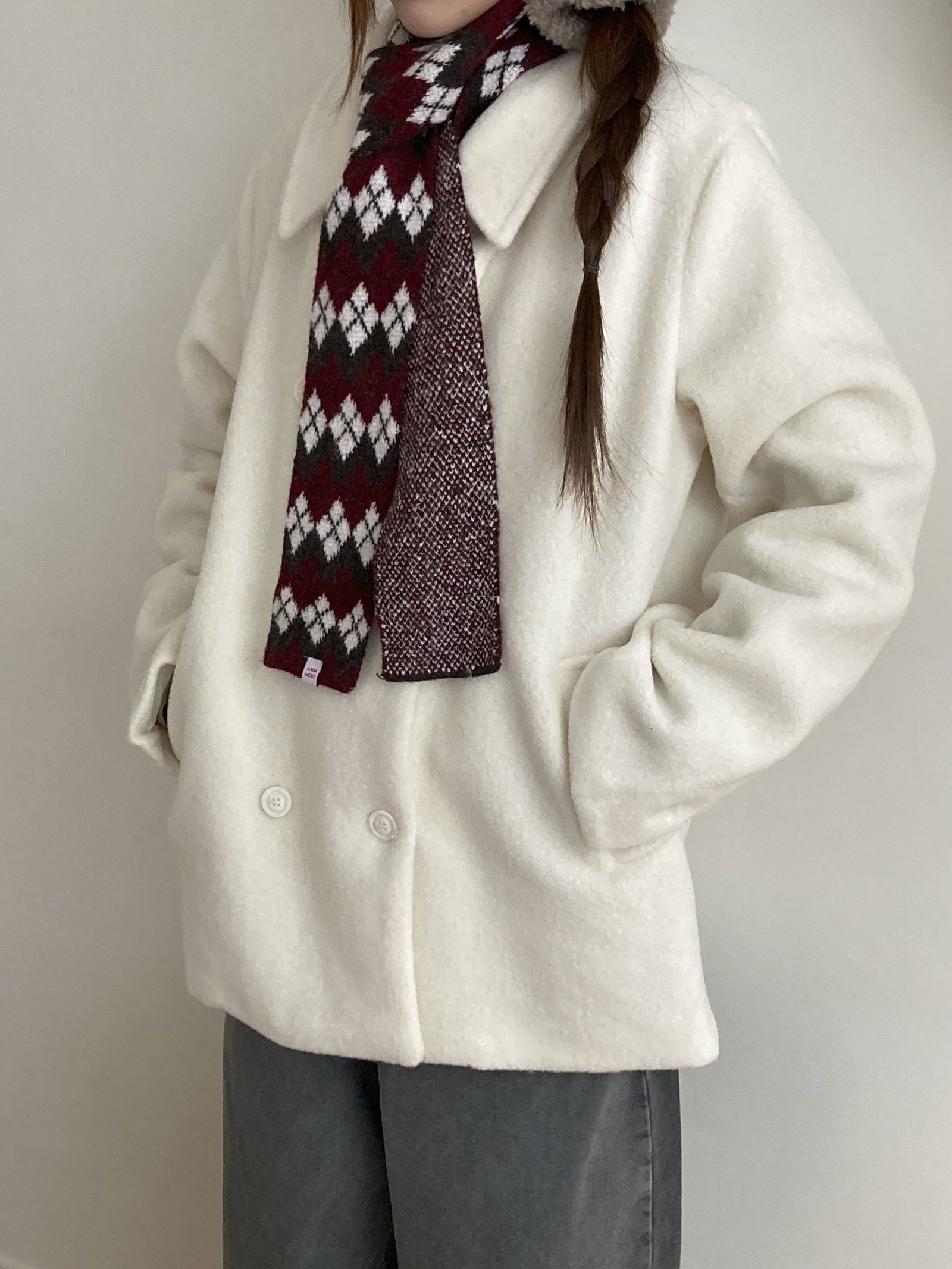 White double-breasted pea coat with a burgundy and gray argyle scarf