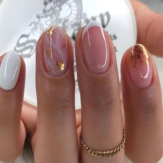 Almond nails with sheer pink base, white French tips and gold foil flakes
