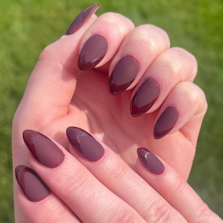 Medium almond nails in deep burgundy alternating between matte and glossy finishes