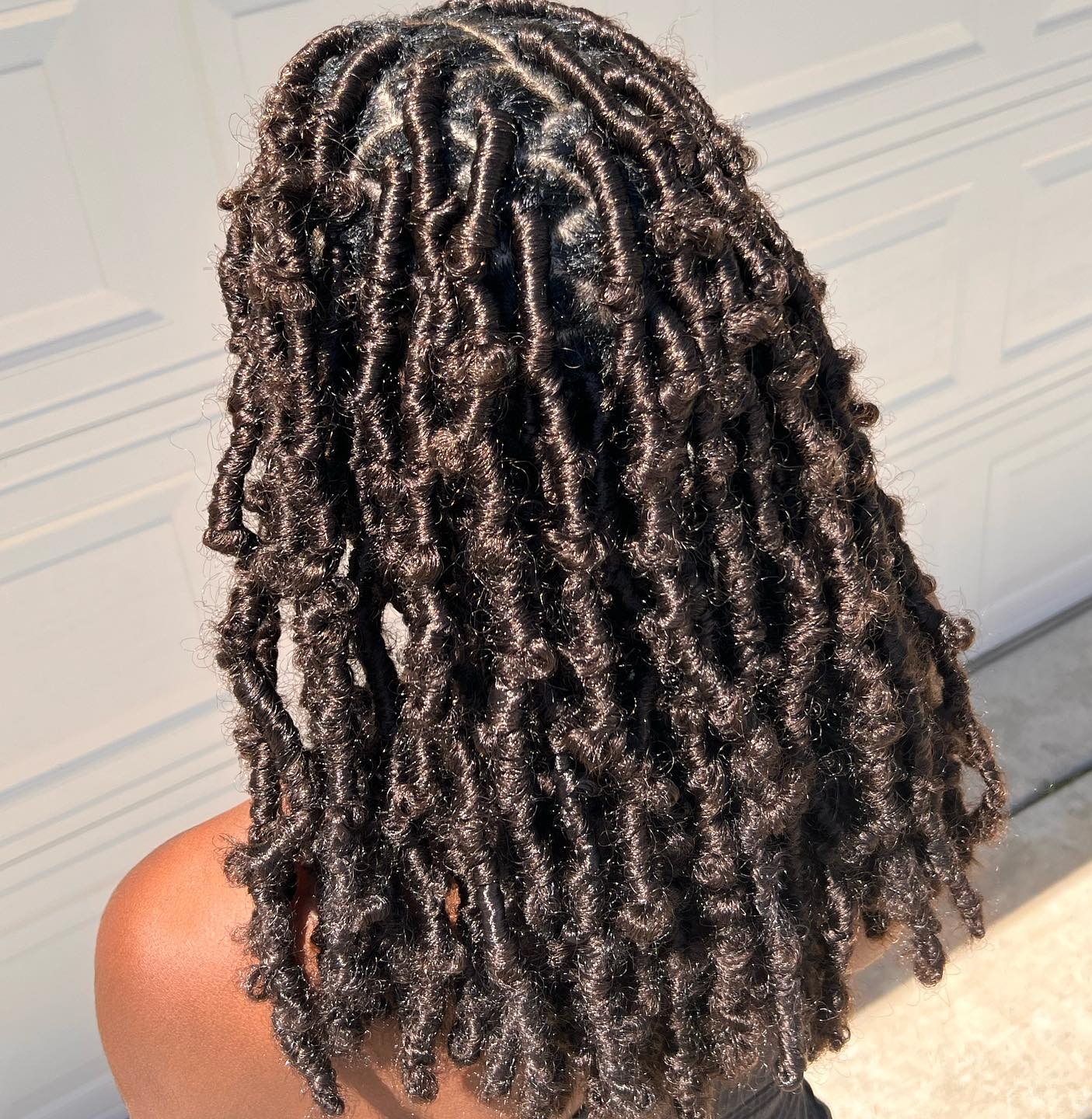 Back view of bohemian butterfly locs with distressed curly texture