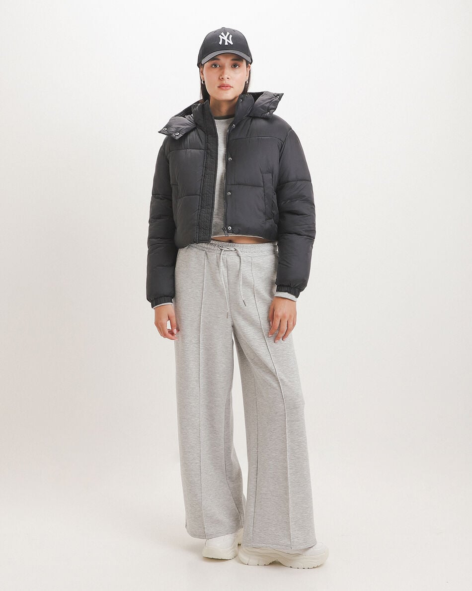 Woman in black cropped puffer jacket, grey sweatshirt, matching sweatpants and chunky white sneakers