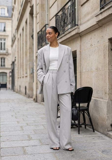 Woman wearing a light grey oversized blazer with matching wide-leg trousers
