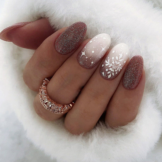 Almond nails in mauve glitter with white snowflake accents