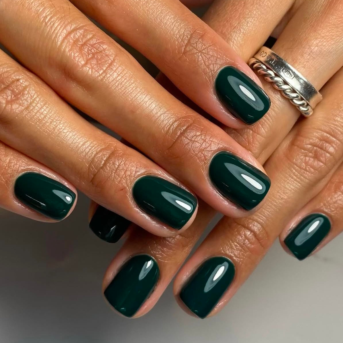 Short squoval nails in deep emerald teal glossy polish