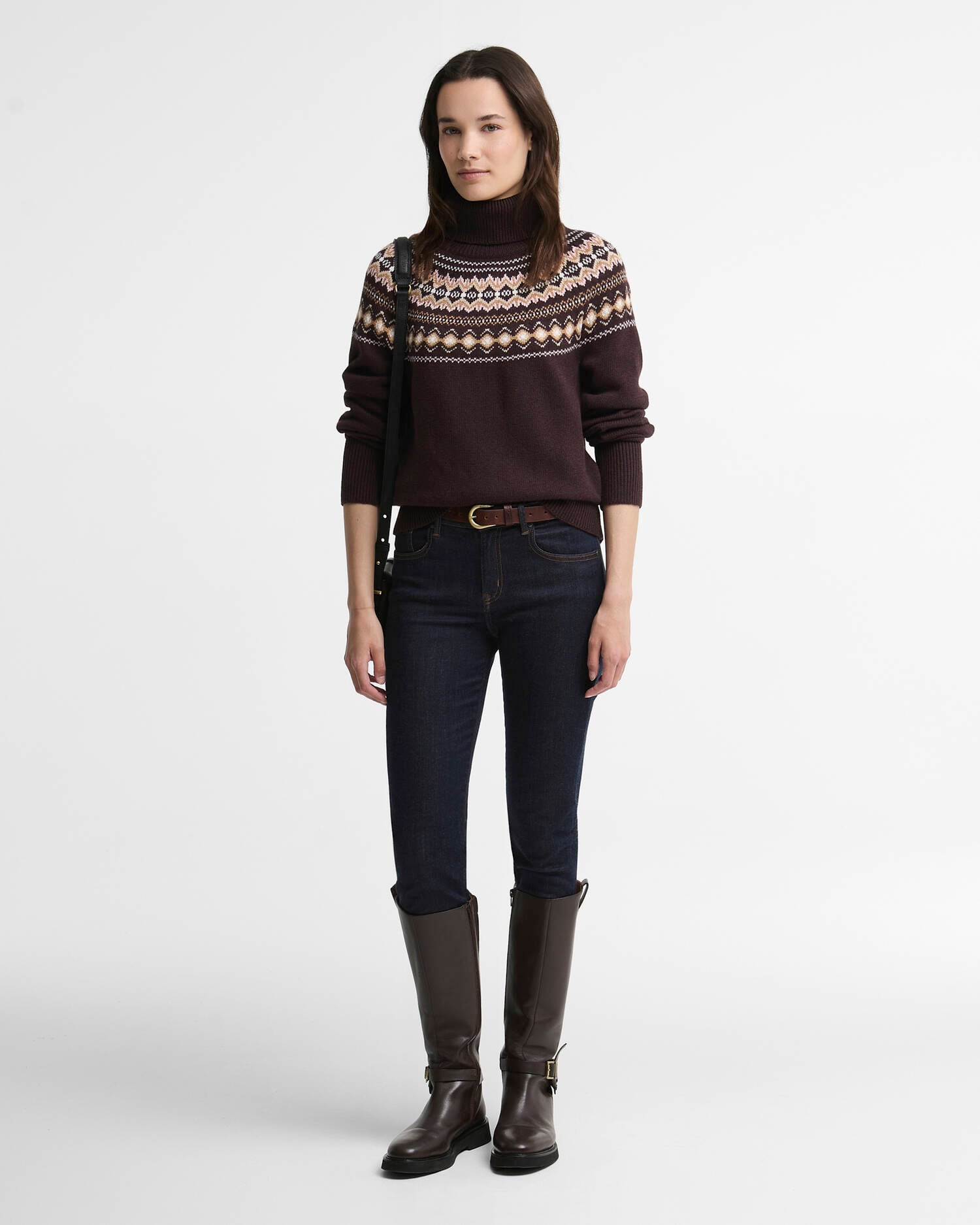 Woman wearing a Fair Isle roll-neck jumper styled with dark denim and shearling boots