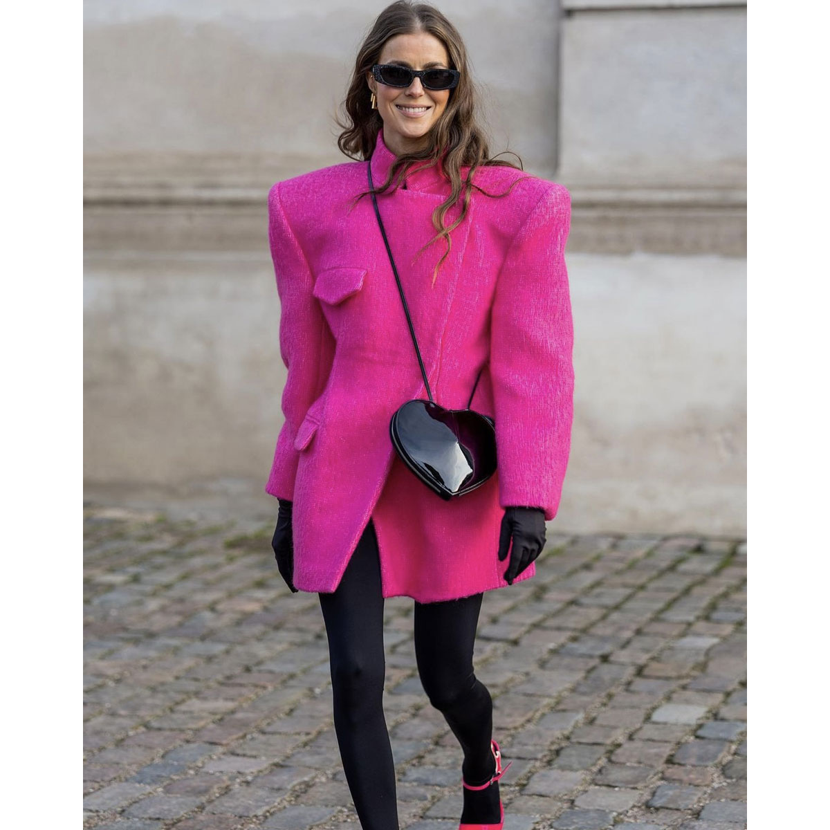 Fuchsia wool coat styled with black tights, black gloves, and a heart-shaped bag