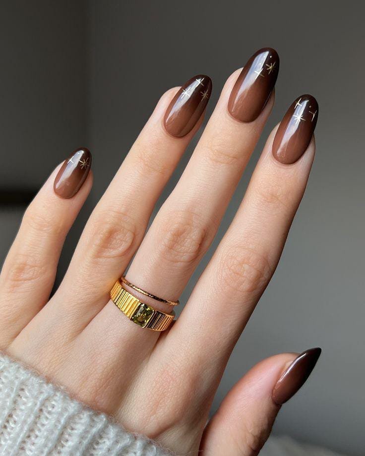 Brown ombré Christmas nails with tiny gold star accents
