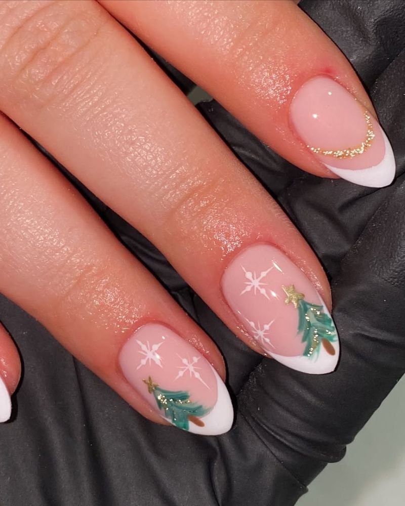 Nude french tip nails with tiny Christmas tree and snowflake art