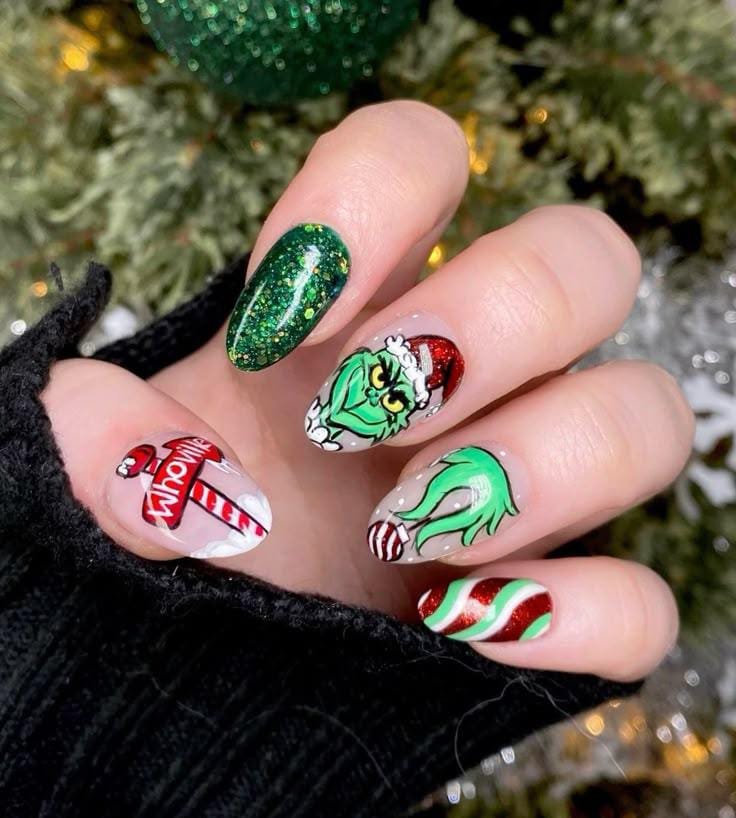 Long almond nails with a detailed Grinch portrait and glitter details