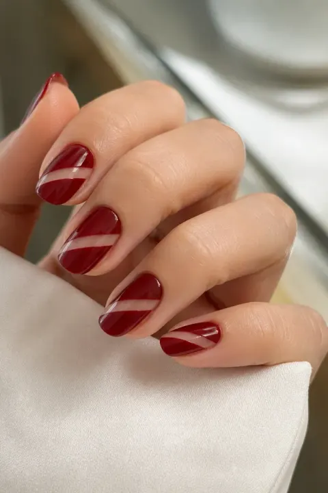 Deep cherry red nails with diagonal negative-space cutouts