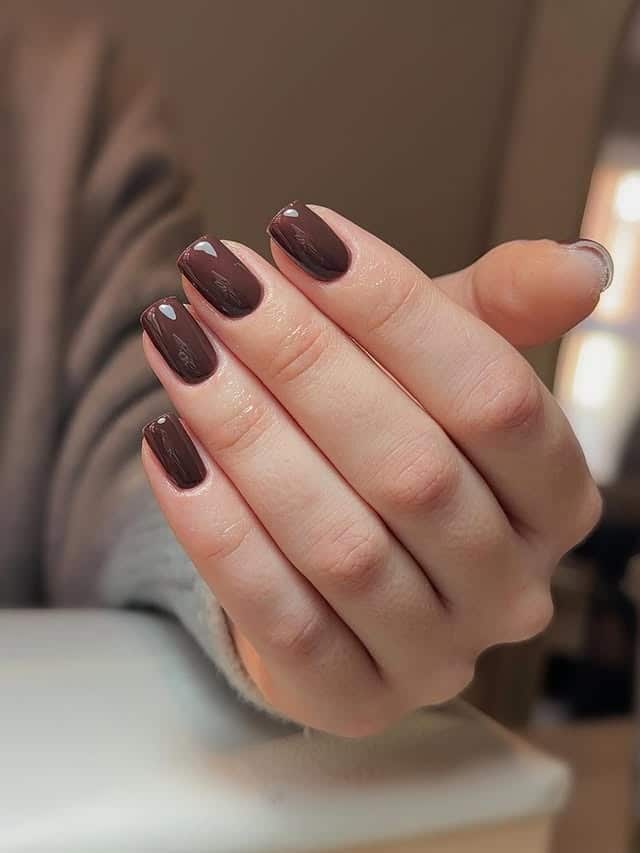 Short squoval nails in a deep espresso-brown crème with a glossy finish; real photography.