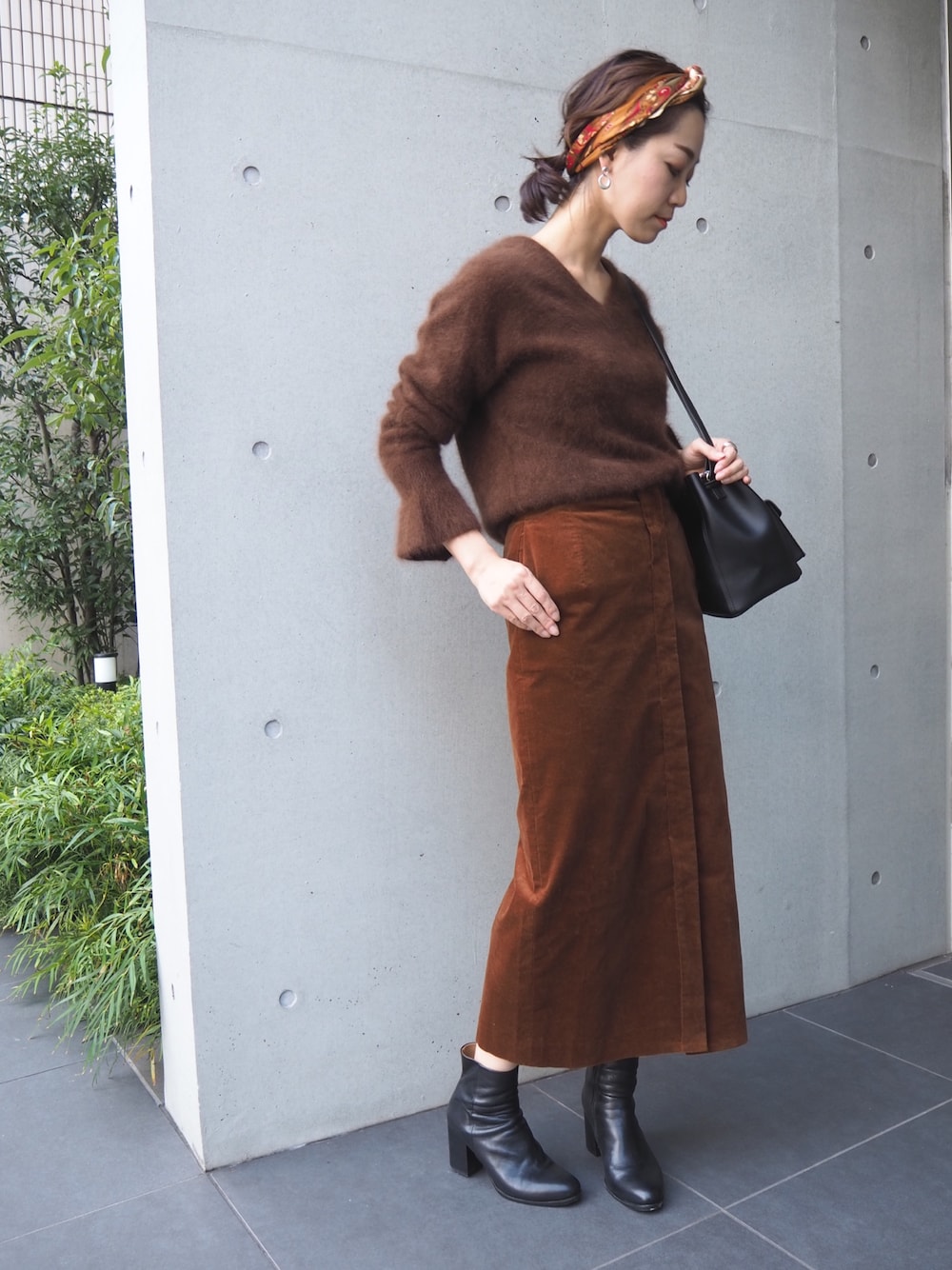Woman in a corduroy skirt with a knit sweater and boots