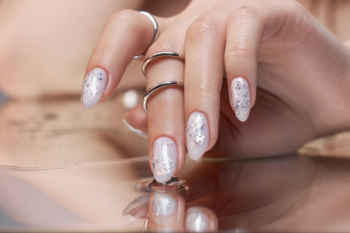 Almond nails in milky white with scattered silver glitter flecks