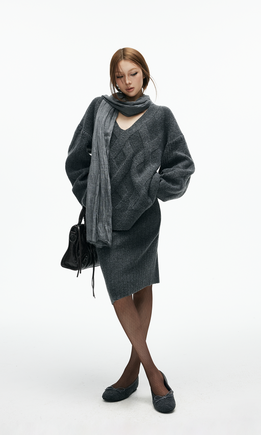 Woman in a knit sweater dress with a chunky scarf and ankle boots