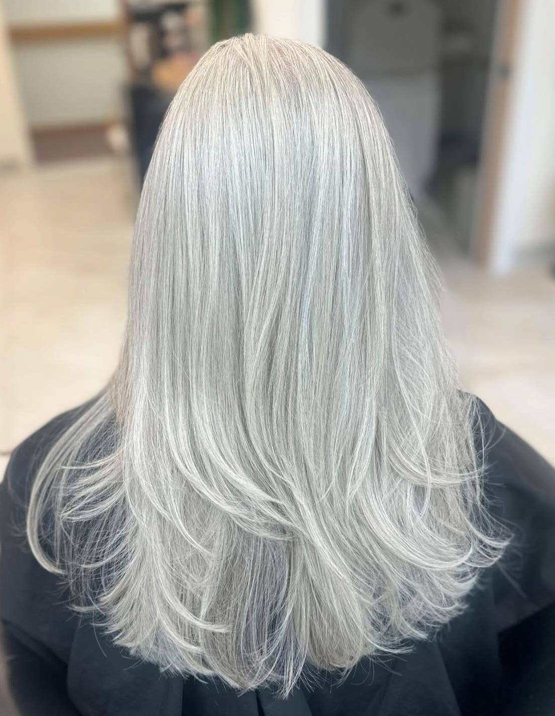 Gunmetal silver balayage on layered wavy hair