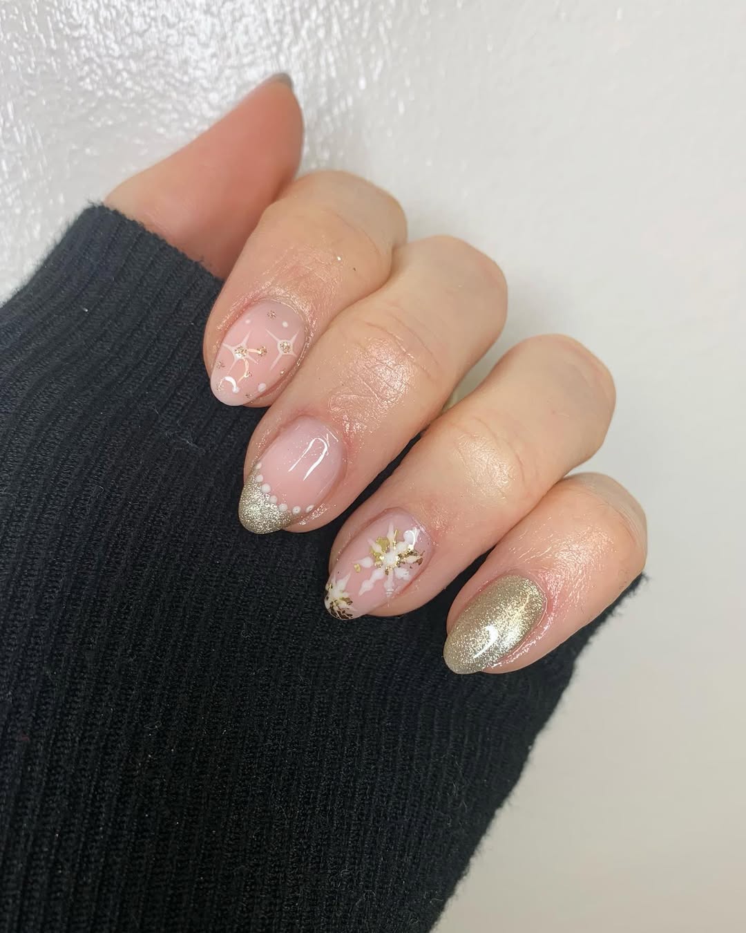 Short blush Christmas nails with gold snowflake French tips and gold accents