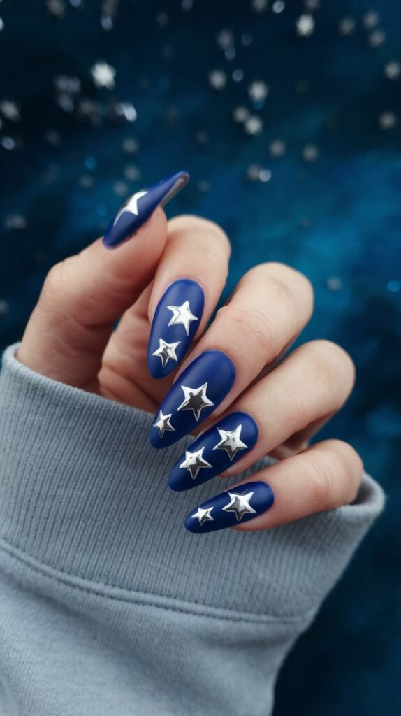 Matte navy almond nails decorated with silver 3D star embellishments