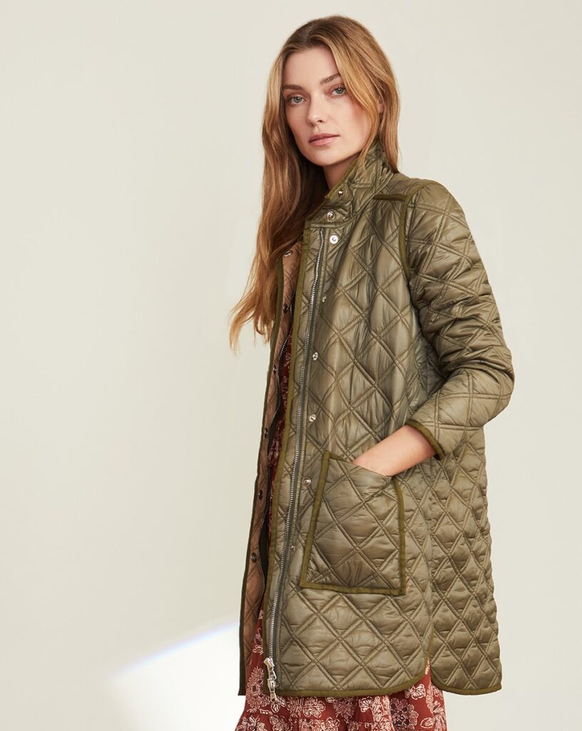 Olive quilted coat worn over a rust floral dress