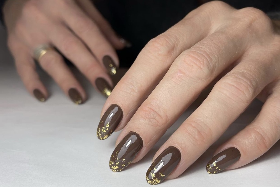 Short almond nails in cocoa brown with gold foil accents