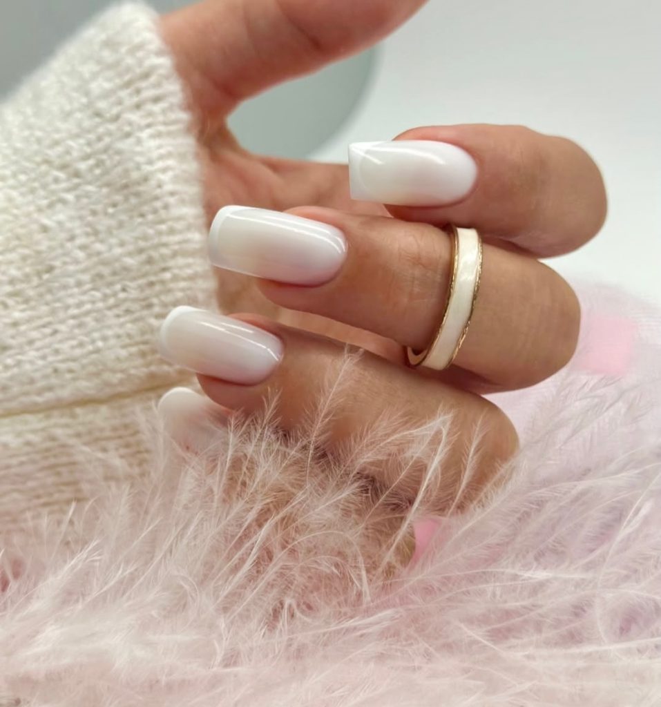 Milky white gradient fading into a sheer pink base on long square nails