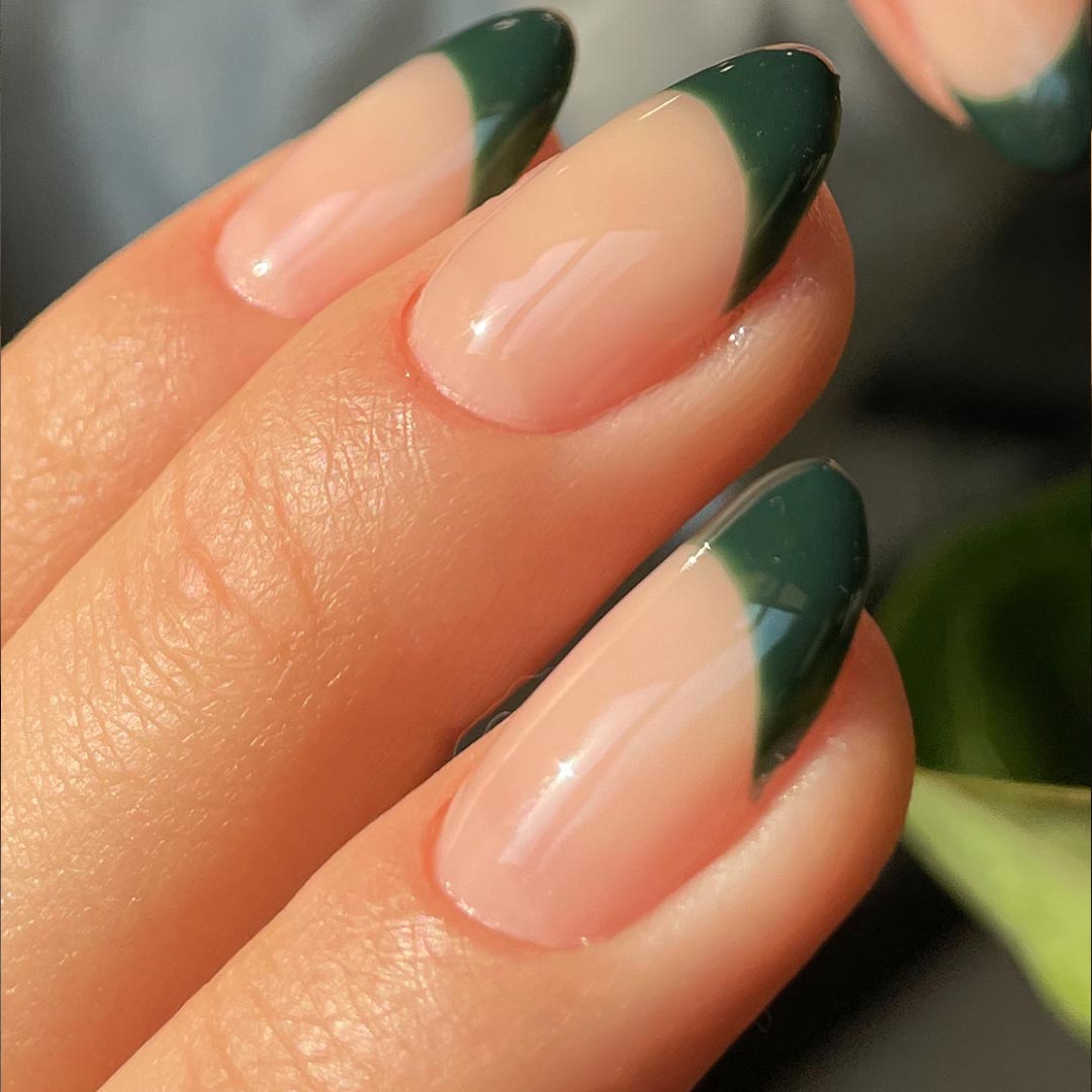 Sheer nude almond nails with forest green French tips