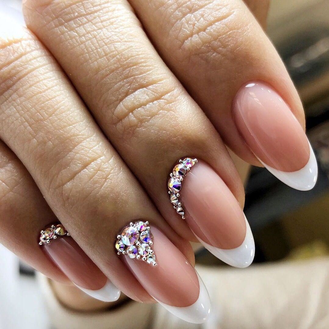 White French tip nails with sparkling rhinestone cluster accents at the cuticles