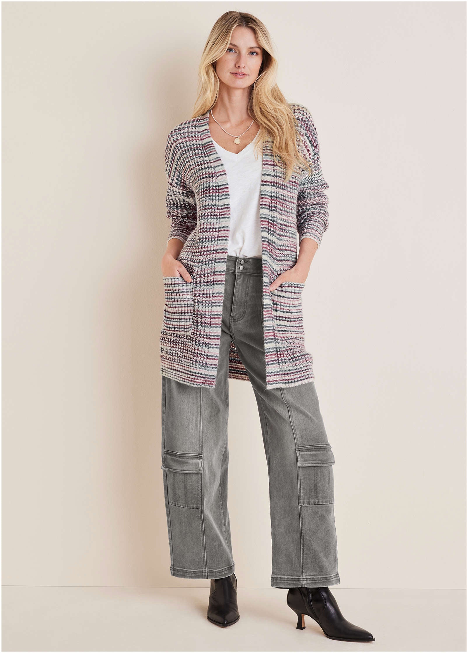 Woman in a long open cardigan, ribbed top and cargo pants with sneakers