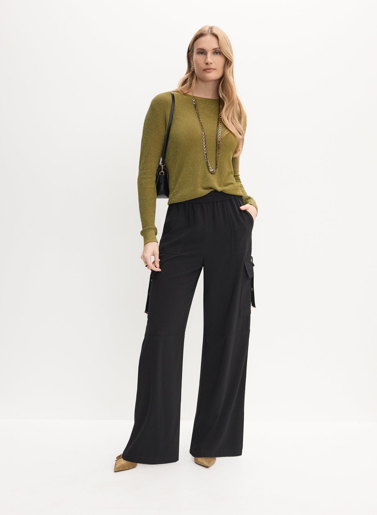 Olive metallic lurex knit sweater with black wide-leg cargo pants and gold flats
